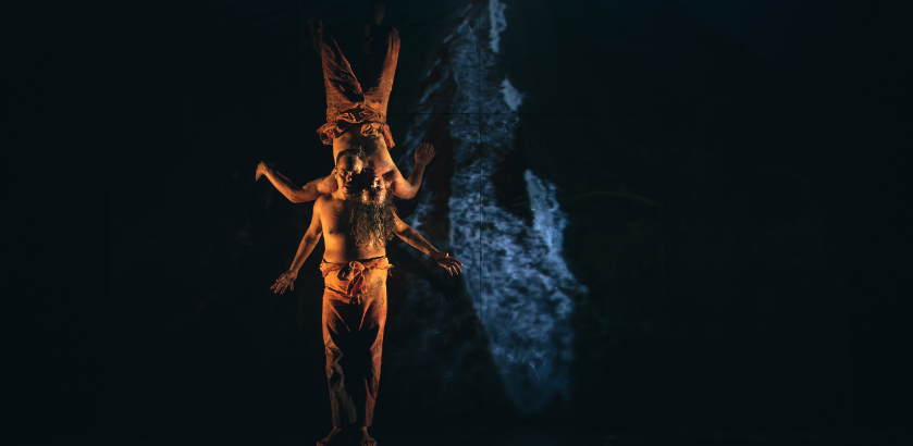 A dance performance featuring two artists set against a dark backdrop.