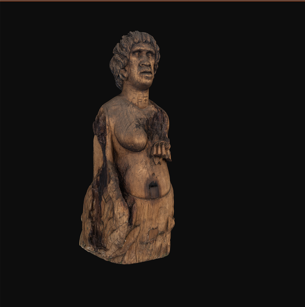 Front right side view of a wooden figurehead representing a First Nations woman against a black background. Native Australian floral motifs and relief of a kangaroo visible at its base. floral motifs and reliefs of an emu and a kangaroo at its base.