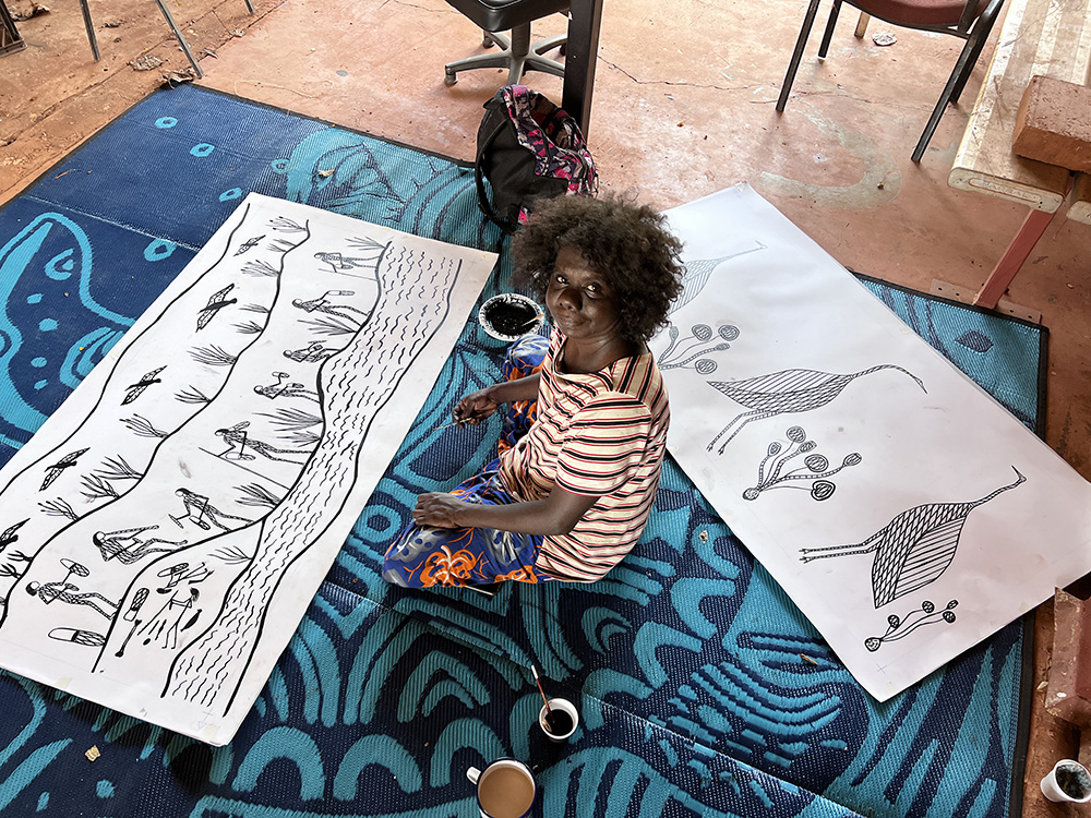 Artist Jay Jurrupula Rostron with two new screen print designs at workshop in Gorrong Gorrong Outstation 2022