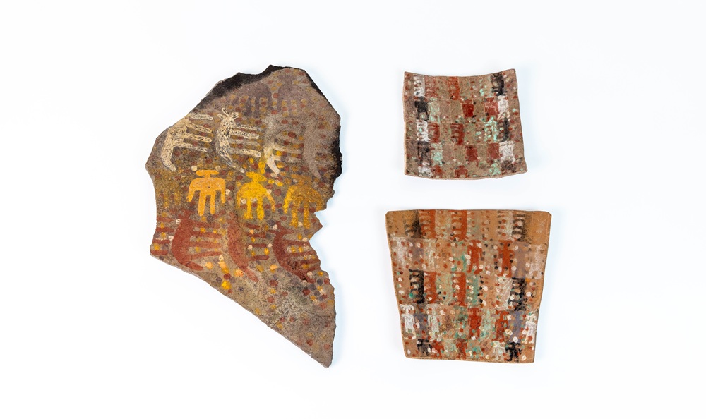 Two ceramic tablets and stone plaque with intricate painted details 