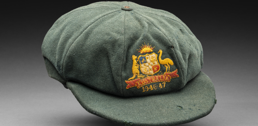 A green cricketer’s cap featuring a woven Australia emblem on the front with the dates 1946-47.