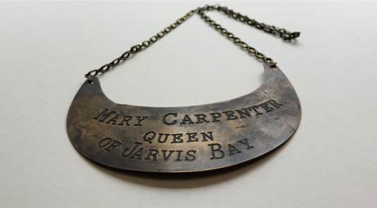 A brass breastplate with inscribed words: Mary Carpenter Queen of Jarvis Bay.