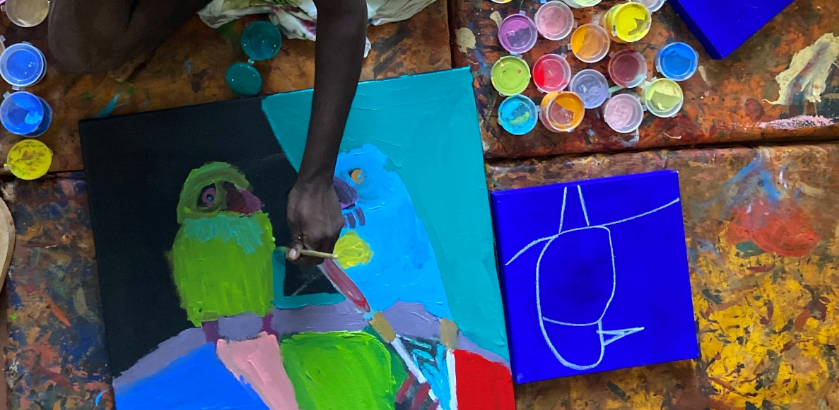 A person painting a vibrant picture of a parrot.