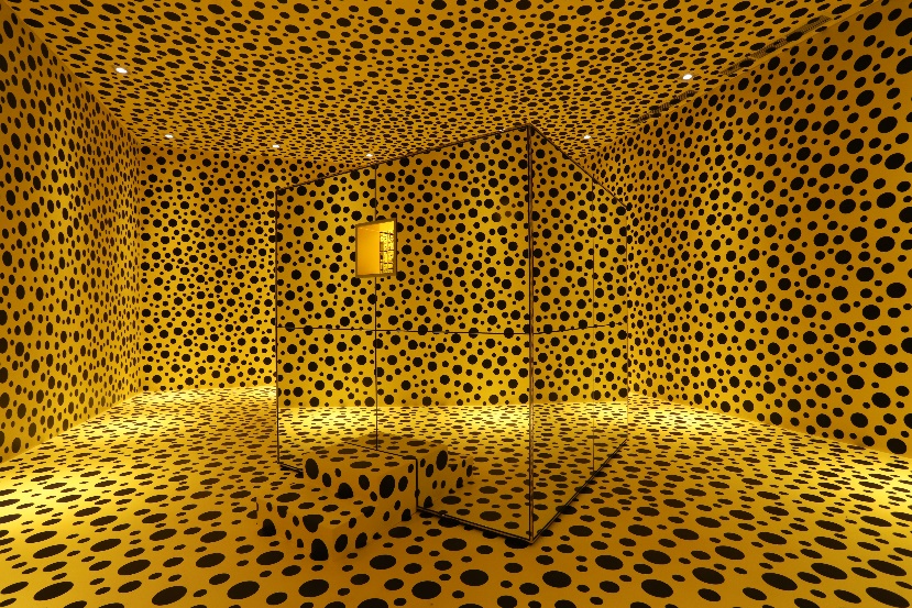 A large room with yellow walls covered in black dots resembling a leopard print pattern.