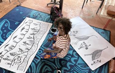 Artist Jay Jurrupula Rostron with two new screen print designs at workshop in Gorrong Gorrong Outstation 2022