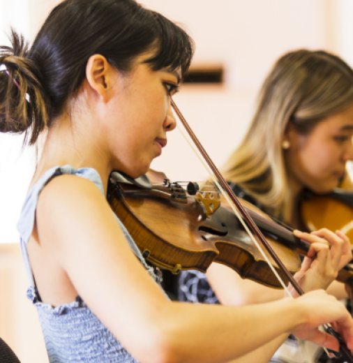 Two young female musicians play violin