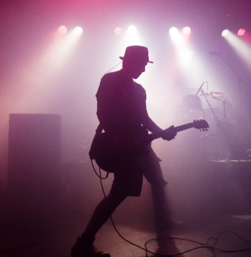 Silhouette of man on stage with guitar