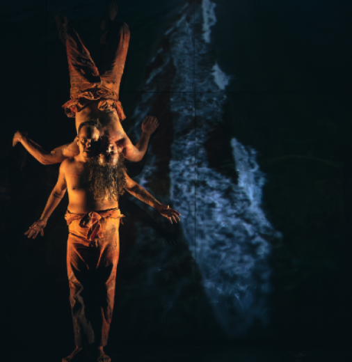 A dance performance featuring two artists set against a dark backdrop.