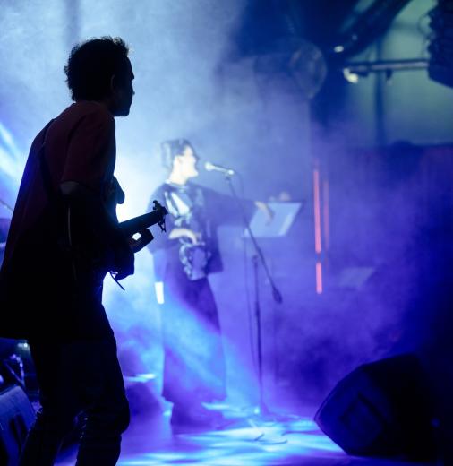 Guitarist and singer performing on stage.