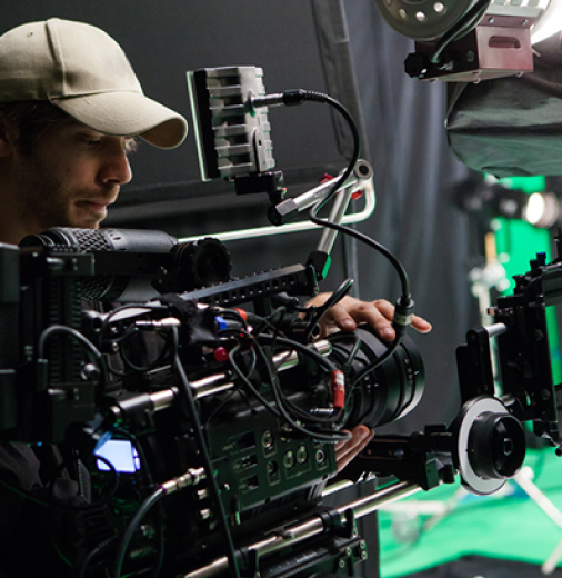 Camera operator standing in film studio in front of camera