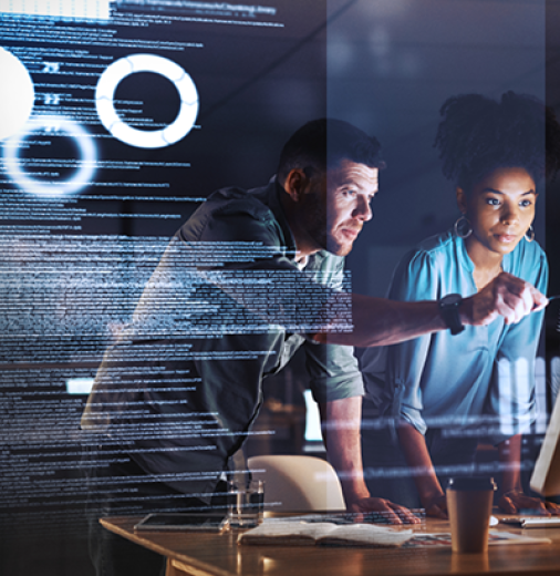 Three tech developers are looking at a computer screen. 