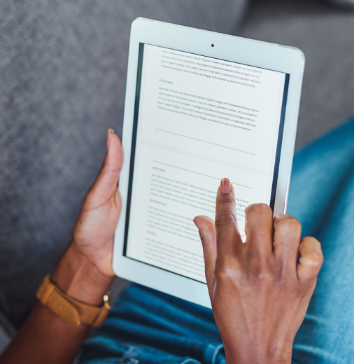 A woman reads an e-book on a couch