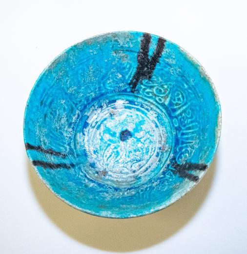 Islamic bowl with turquoise glaze and black inscription in Nasta’liq script wishing health and prosperity to its owner.