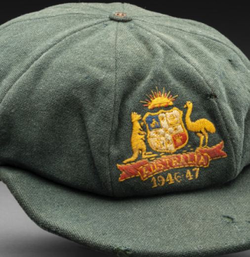 A green cricketer’s cap featuring a woven Australia emblem on the front with the dates 1946-47.