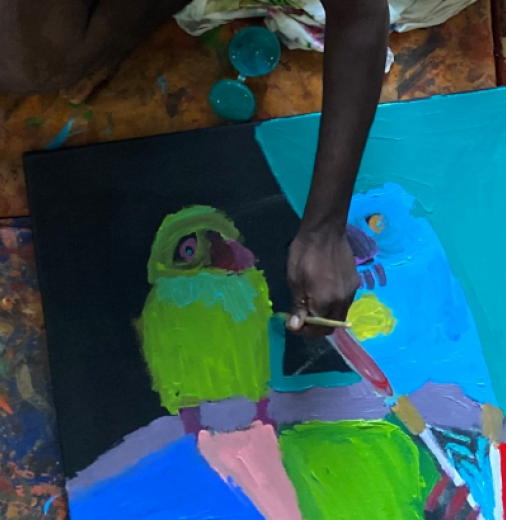 A person painting a vibrant picture of a parrot.