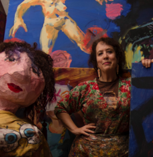 Artist Wendy Sharpe stands amongst her colourful paintings and artworks.