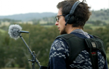 AFTRS image of male with an audio setup of mic and headphones.