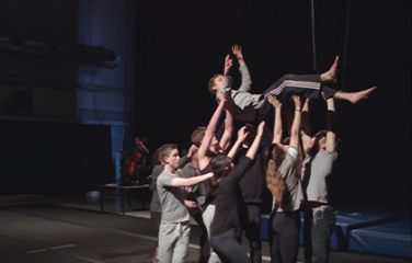 Group of people holding one person up.