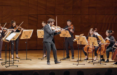 The Australian National Academy of Music. Performance of strings on stage with conductor. Stringed instruments from left to right include, violins, violas, cellos and double bass.