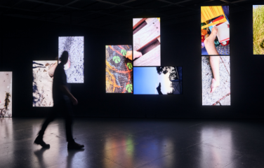 Person walking past Bruno Booth, Body Shots, 2022, video installation.