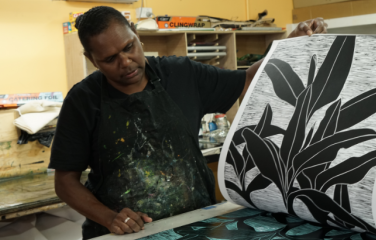 First Nations artist at the printing press in an art centre.