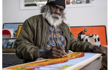 Mervyn Rubuntja 2021, painting in the Iltja Ntjarra Studio. Image courtesy: Shaana McNaught, Tourism NT.