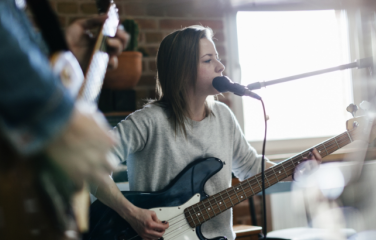 musician playing guitar and singing