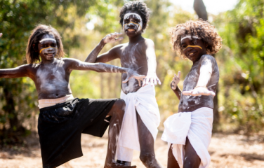 Three young Balkarranga clan members posing outside, ready to perform.